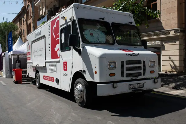White food truck by LiveChef at a bustling street festival under sunny skies.